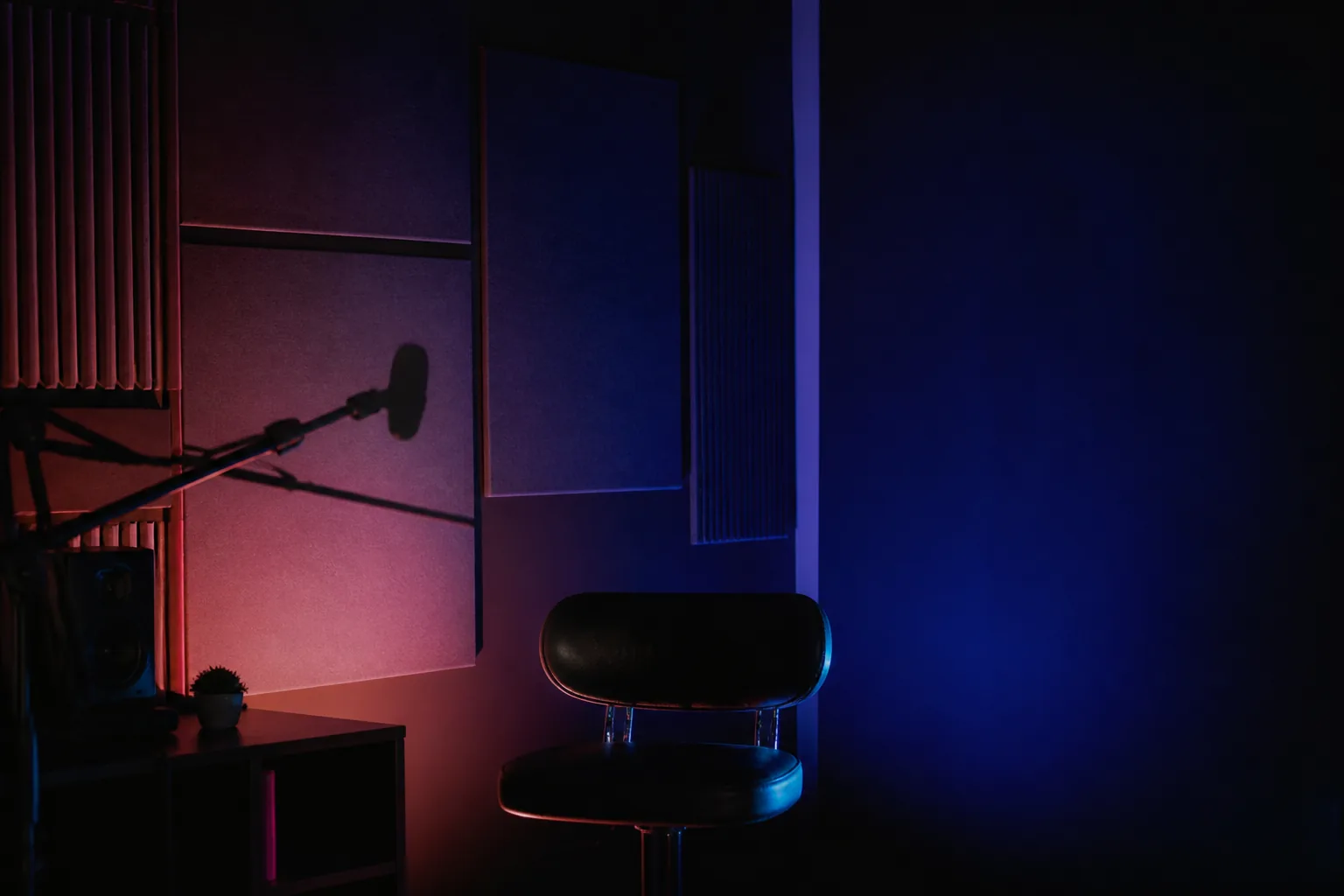 Rincón de estudio de creación de contenido en penumbra con luz indigo y coral